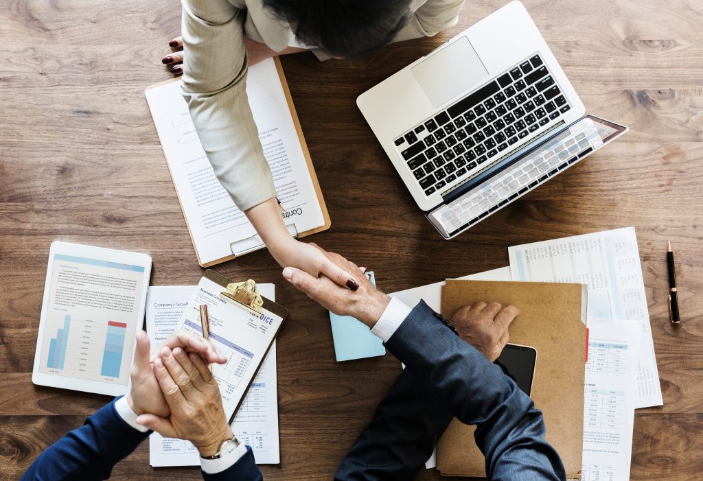 business people shaking hands together 1 scaled